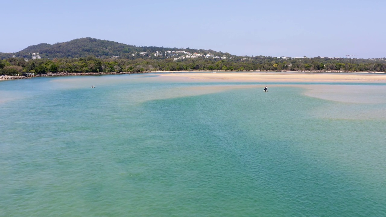 一个美丽的空中/无人机拍摄的原始热带海滩天堂，与水晶清澈的绿松石水遇见雨林。在暑假期间，在澳大利亚阳光海岸的努沙拍摄。拍摄在惊人的4K分辨率视频素材