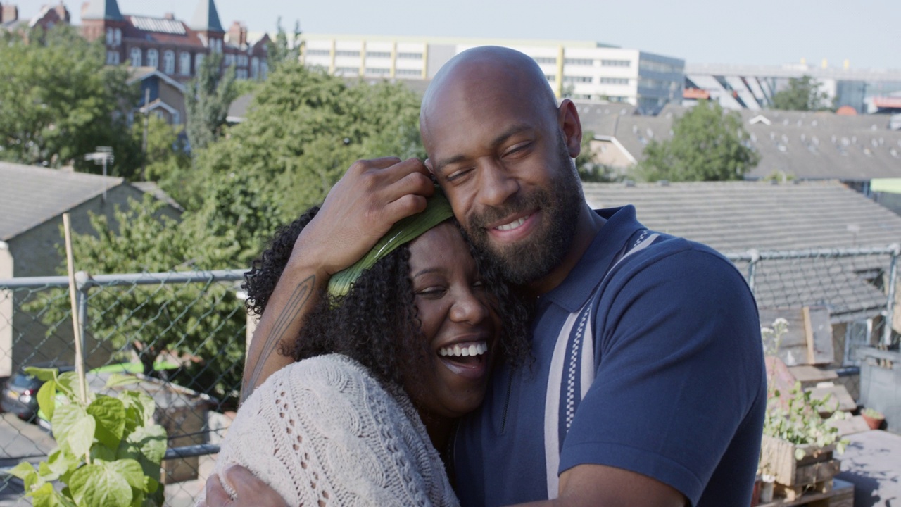 一对成年黑人夫妇在屋顶露台上拥抱微笑视频素材