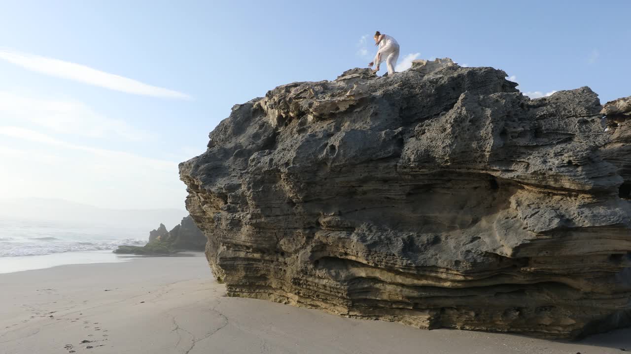 一个十几岁的女孩在沃克湾自然保护区的岩石海岸探险视频素材
