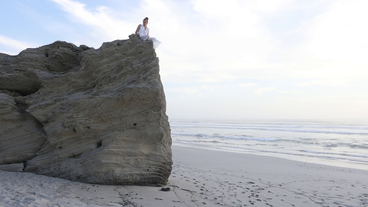 一个十几岁的女孩在沃克湾自然保护区的岩石海岸探险视频下载