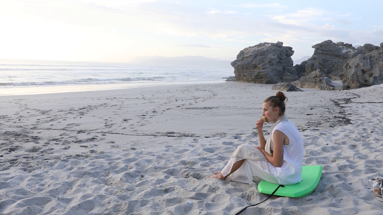 一个十几岁的女孩在海滩上放松，岩石海岸线，沃克湾自然保护区视频素材