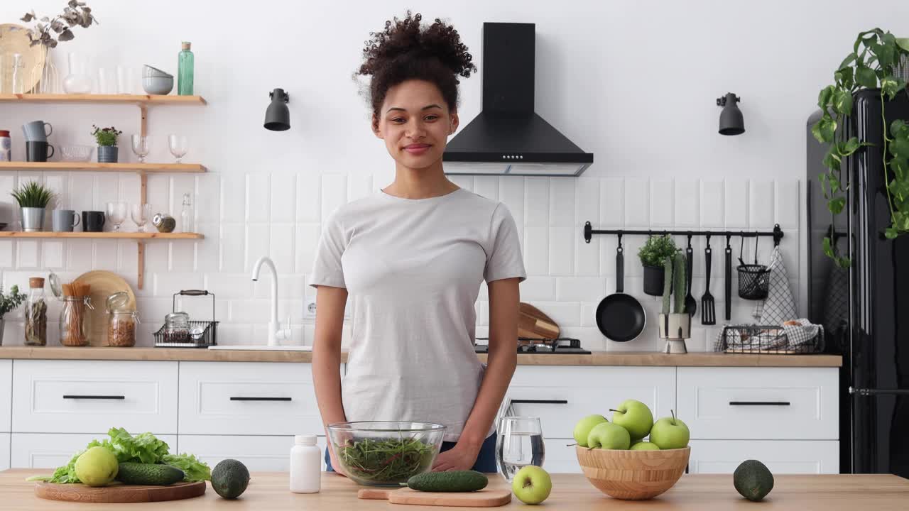 快乐的非裔美国女性博主，在家庭厨房的视频博主用网络摄像头为他的追随者评论营养补充剂。健康生活方式网络研讨会概念视频下载