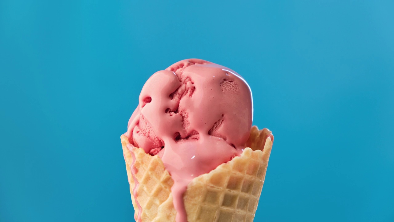 草莓冰淇淋在粉红色的背景上融化。冰淇淋融化的时间。视频素材