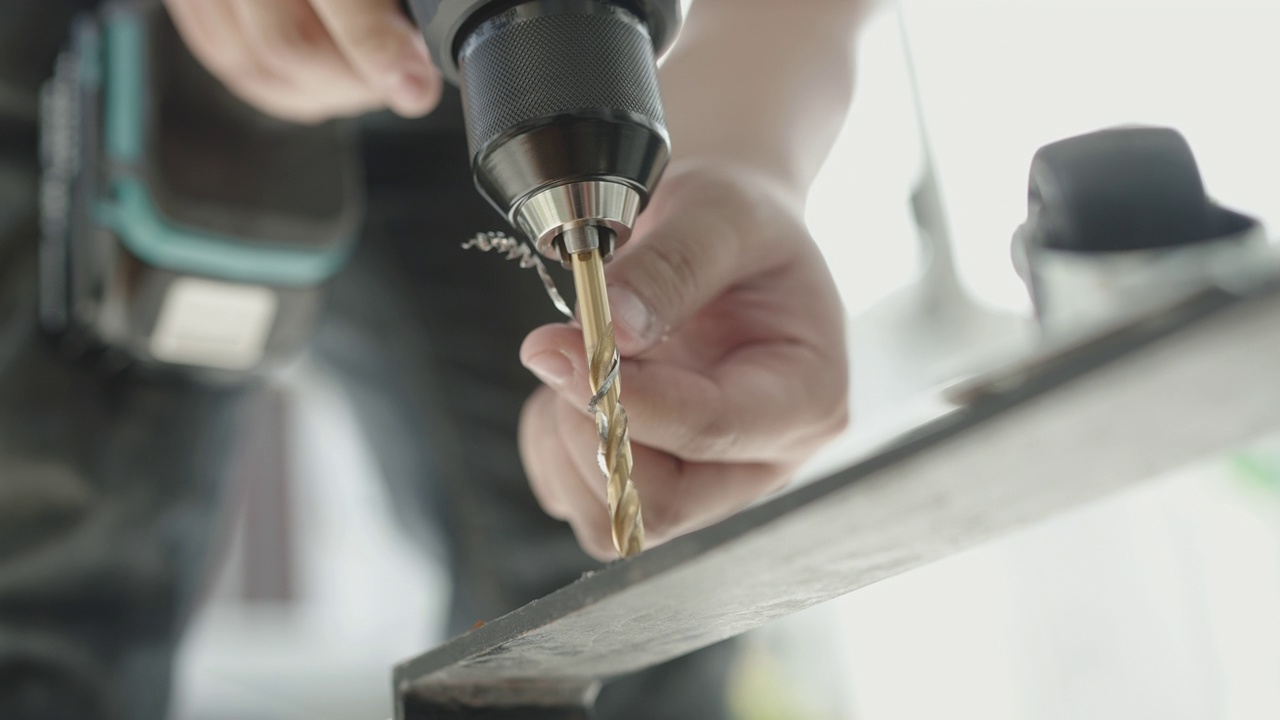 下面的角度的工匠使用电动手钻螺丝金属工作台DIY工作视频下载