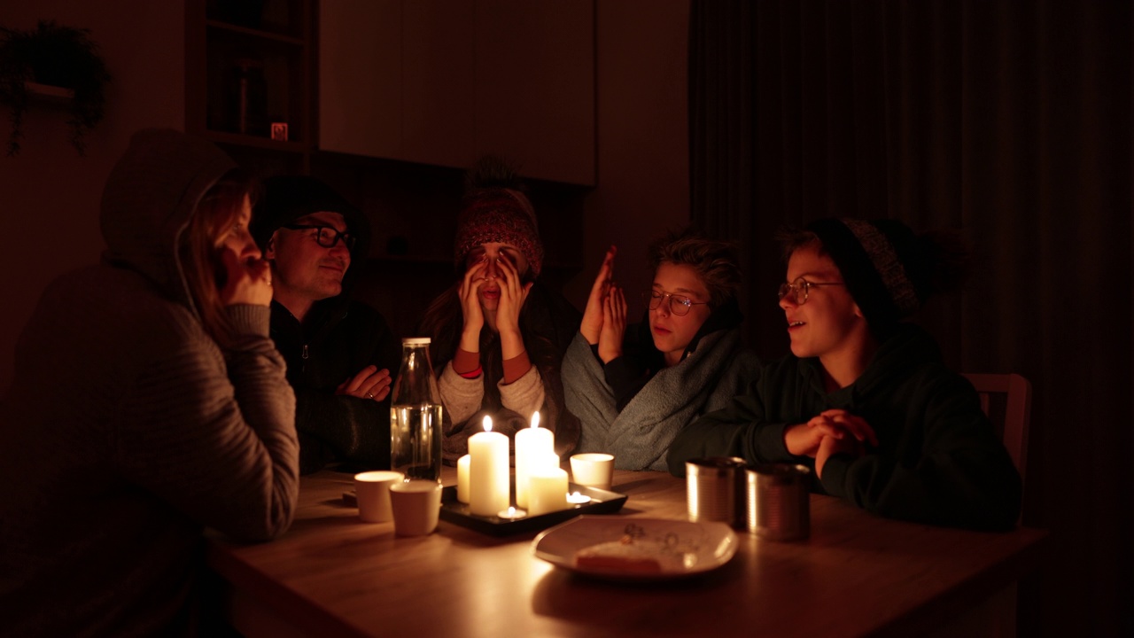 停电期间一家人围坐在蜡烛旁。视频素材