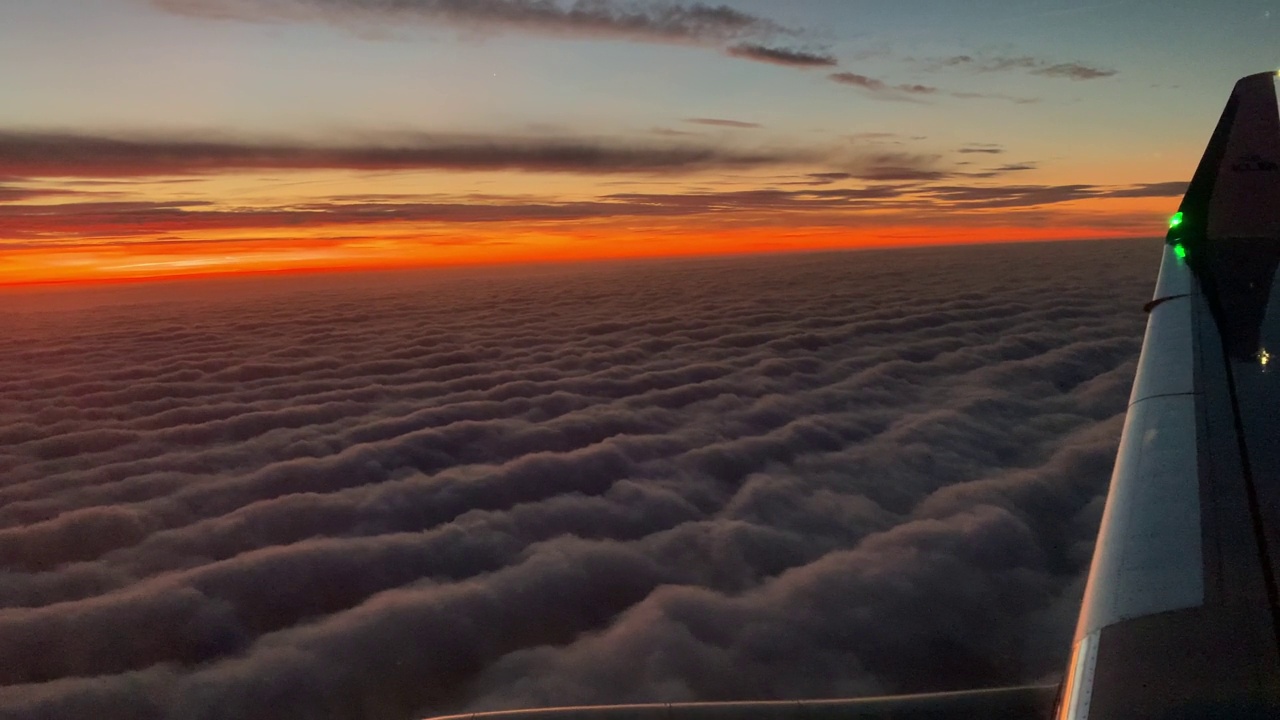 阿姆斯特丹12 17 2020飞机飞行。一架荷兰皇家航空公司的机翼在日出天空的云层上飞行。从飞机窗口看到的景色。飞机。乘飞机旅行。4 k UHD视频视频下载