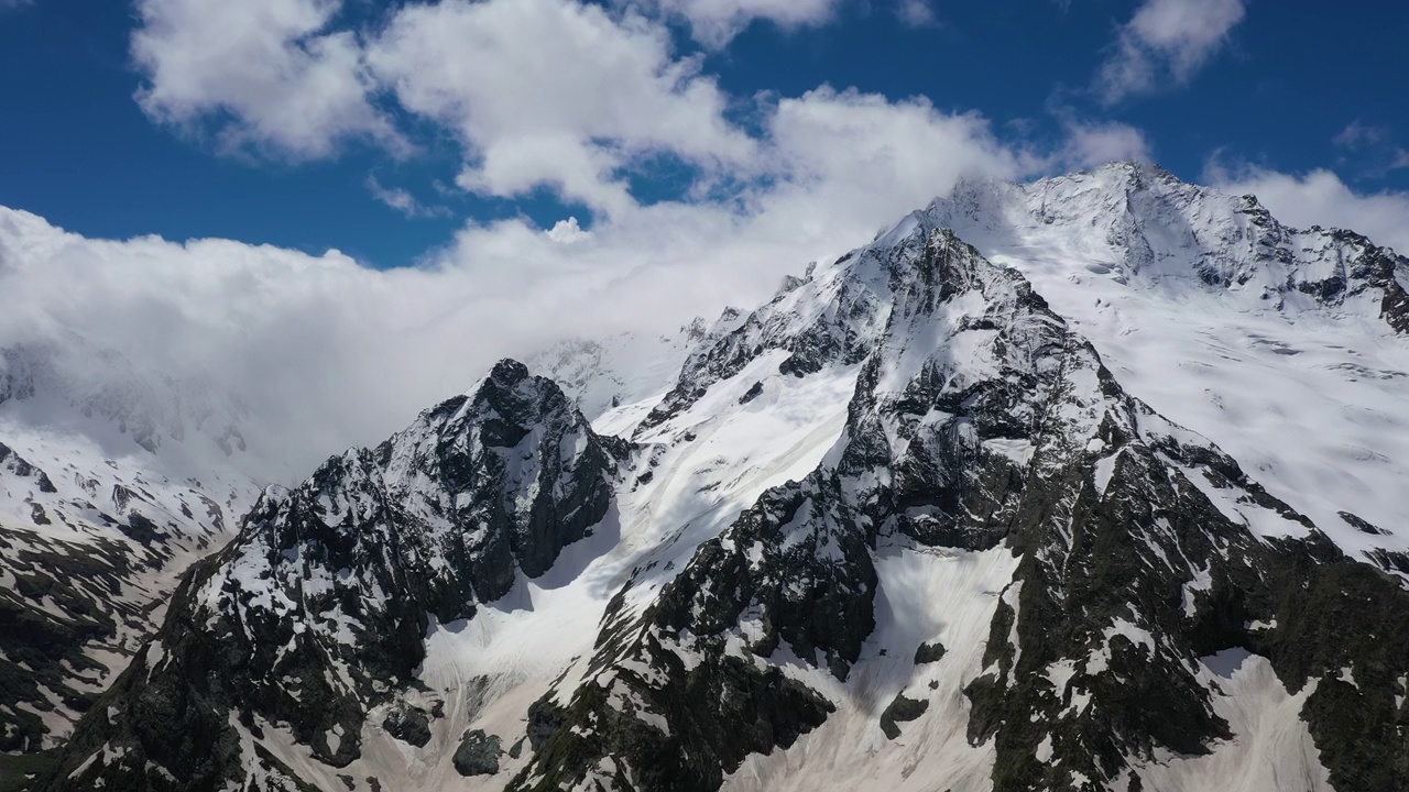 飞机穿越高山云层，飞过美丽的雪峰和冰川。视频素材