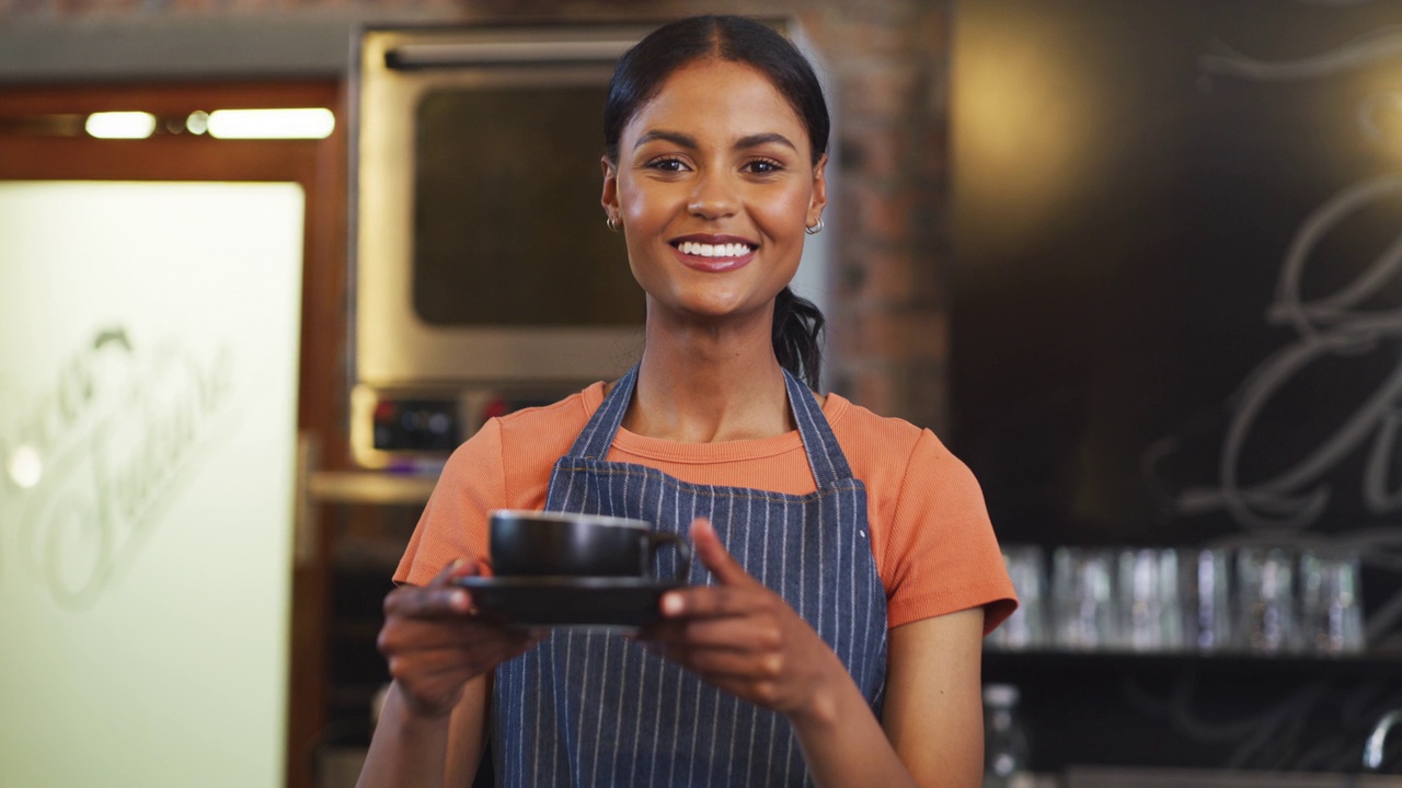 一个年轻女服务员在咖啡馆拿着一杯咖啡的4k视频片段视频素材