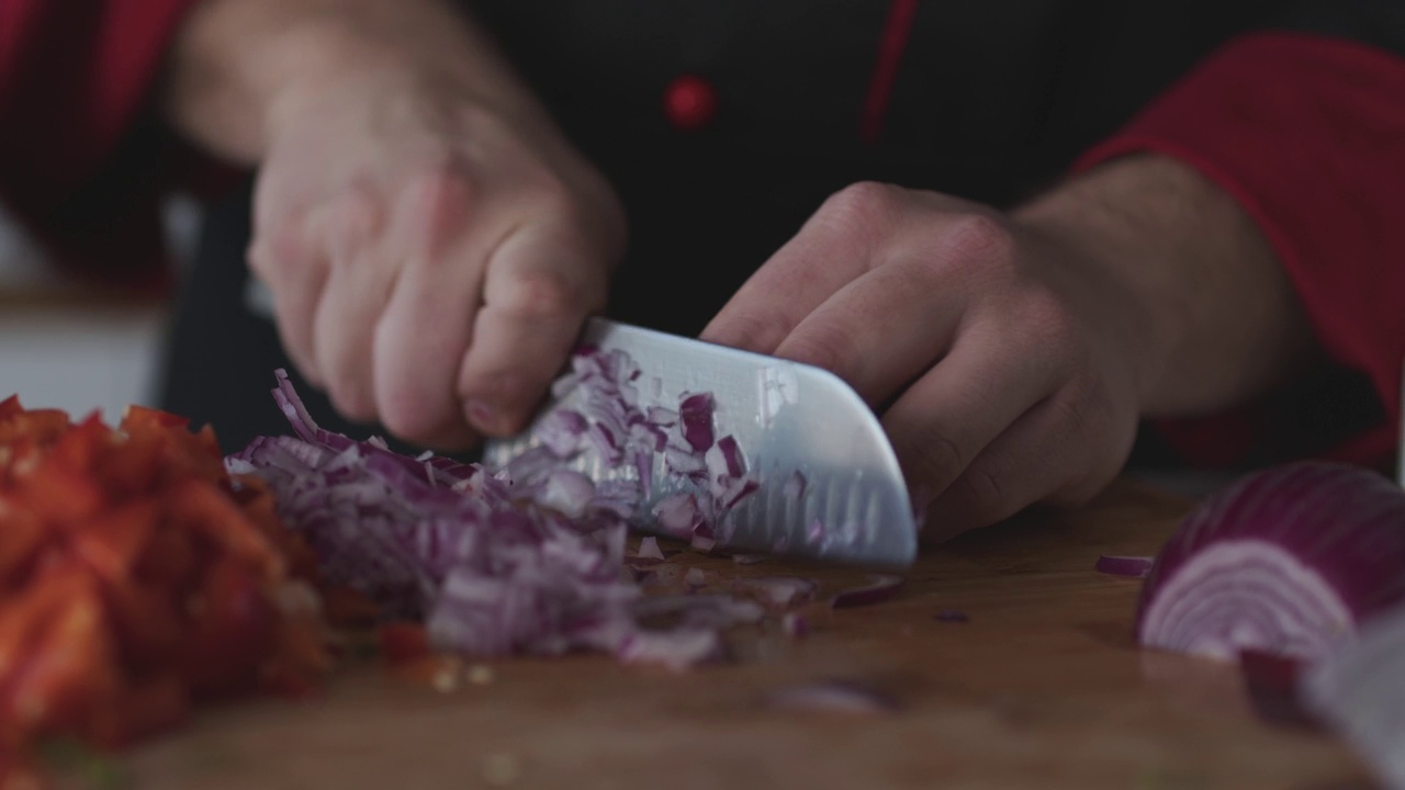 熟练的厨师用菜刀将红洋葱切丁视频下载