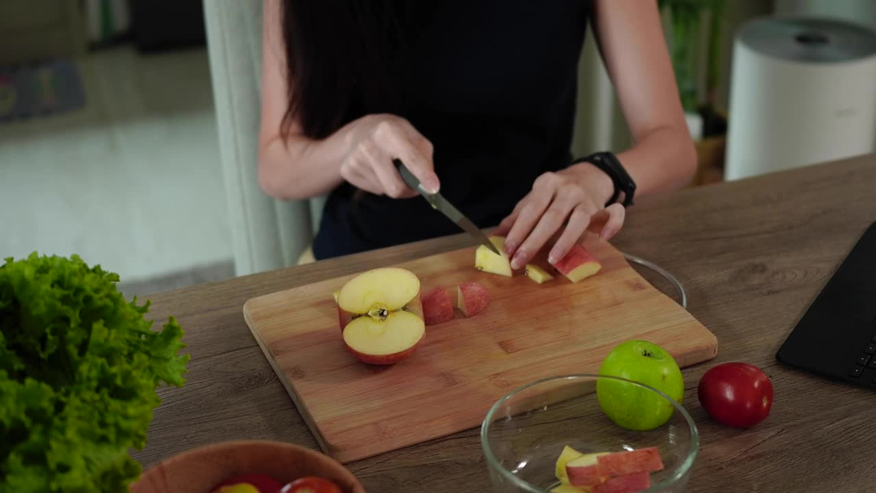 妇女在家庭现代化的家庭厨房里做健康的蔬菜沙拉。视频素材