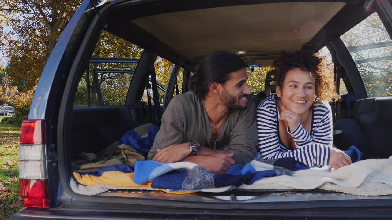 一对年轻夫妇在车后面放松和露营视频下载