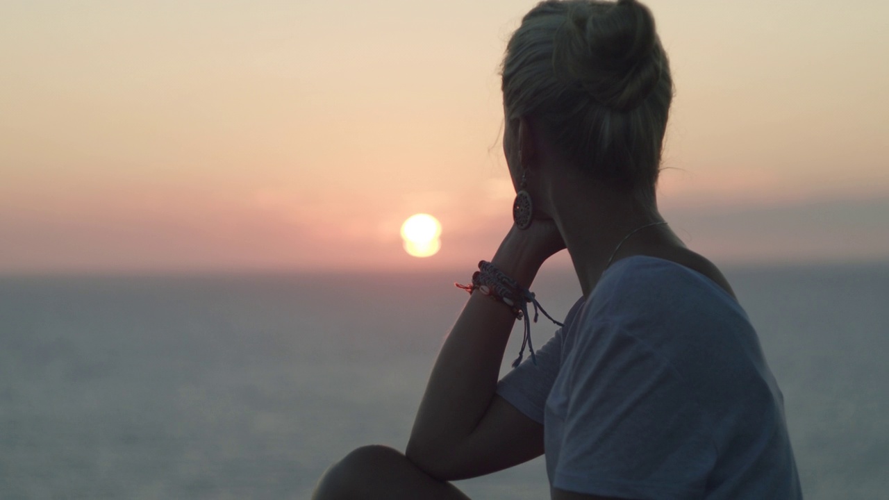 欣赏日落和日出的女人。后视图。女孩在海滩上放松。地中海。电影的冥想。视频素材