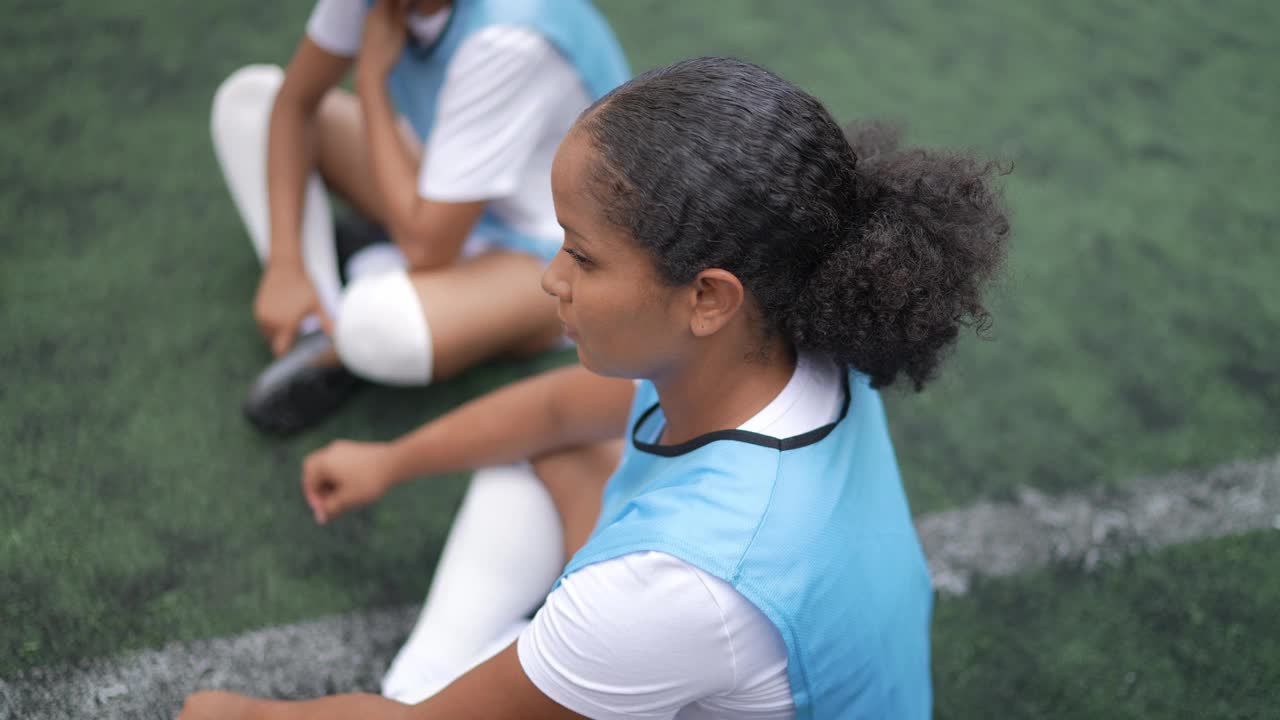 一名女子足球运动员坐在运动场上的肖像视频下载