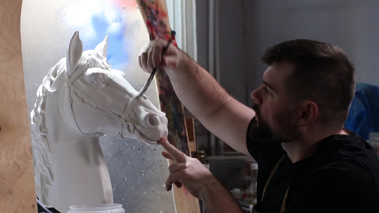 工匠用石膏铸成马。石膏模具和塑料面具雕刻和绘画视频下载