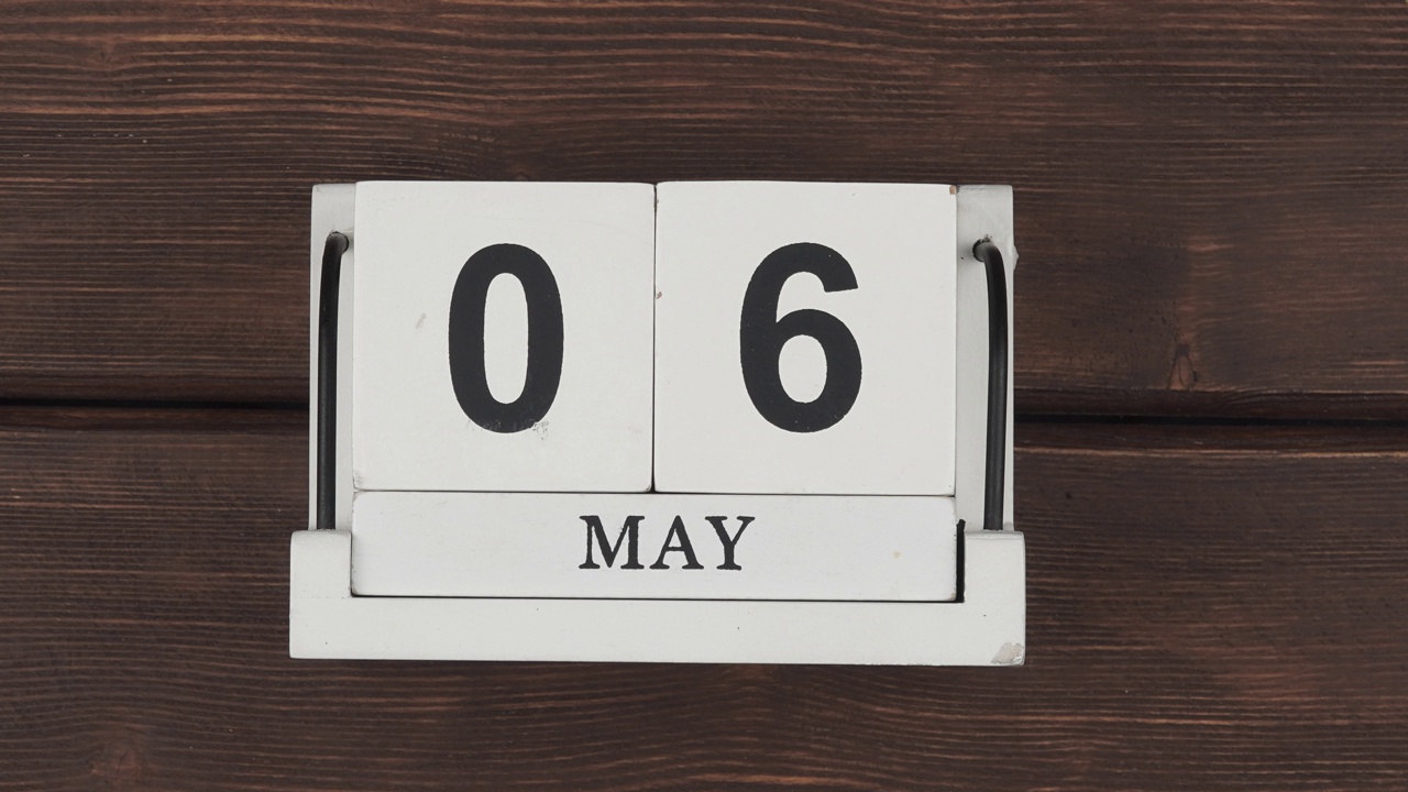 5、五月历法，天变天变。木日历与日期月和日在一个木制的桌子上。快节奏的时间在一个月。加速日历。停止运动。视频素材