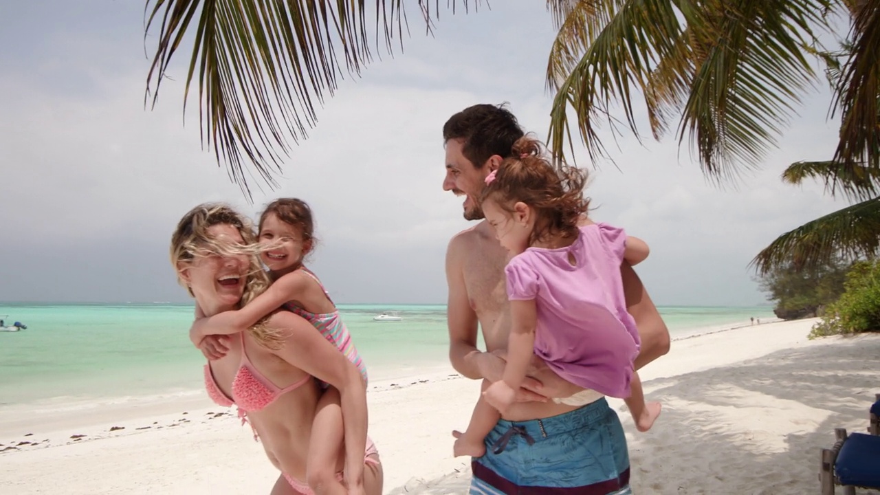 幸福的家庭在夏日的沙滩上玩得很开心。视频下载