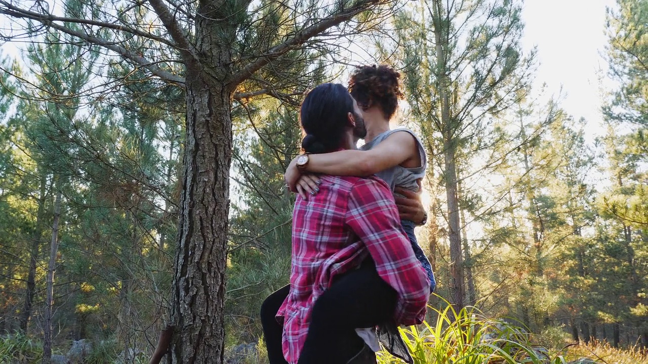 好玩的情侣在阳光明媚的树林里徒步旅行视频下载