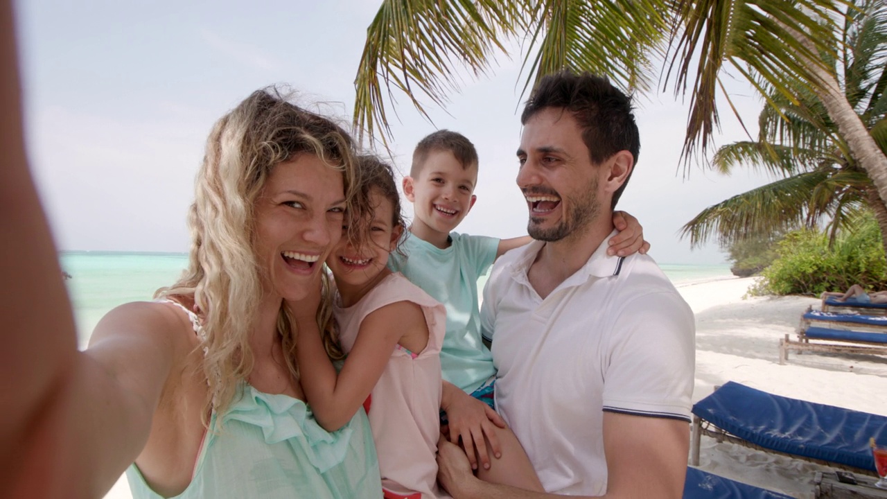幸福的家庭在夏日的沙滩上制造回忆。视频下载