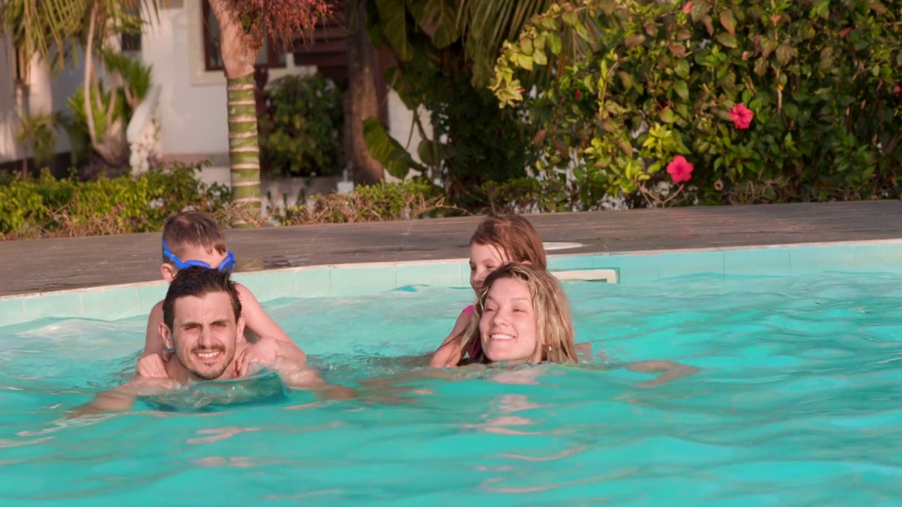 幸福的家庭有乐趣，而游泳在游泳池。视频下载