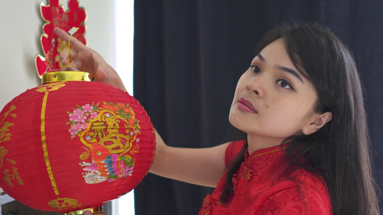 美丽的年轻亚洲妇女装饰她的房子为中国新年视频下载