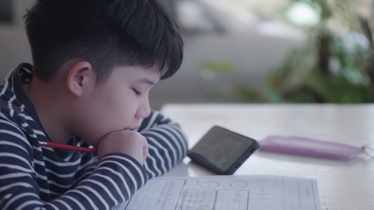 亚洲男孩在家做家庭作业视频素材
