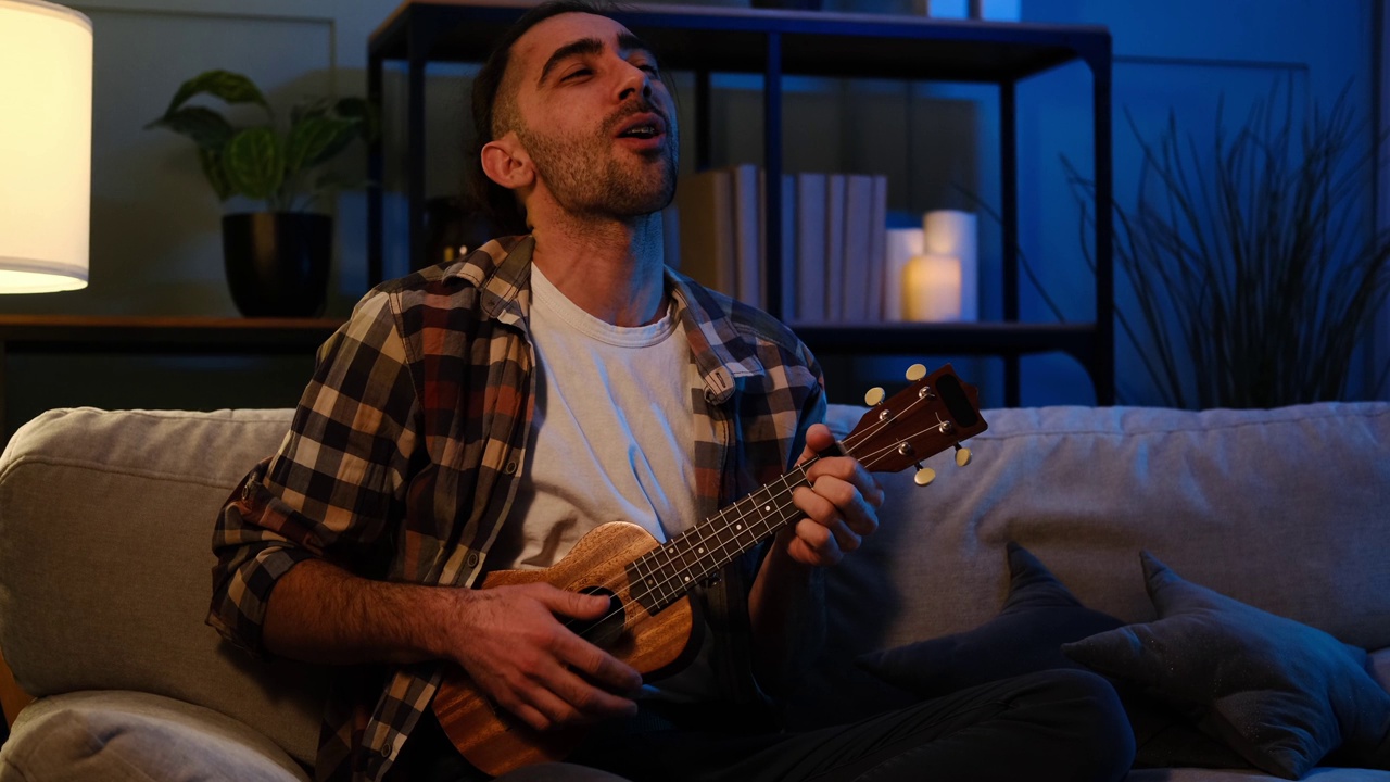 男人在家里唱歌，弹尤克里里吉他视频下载