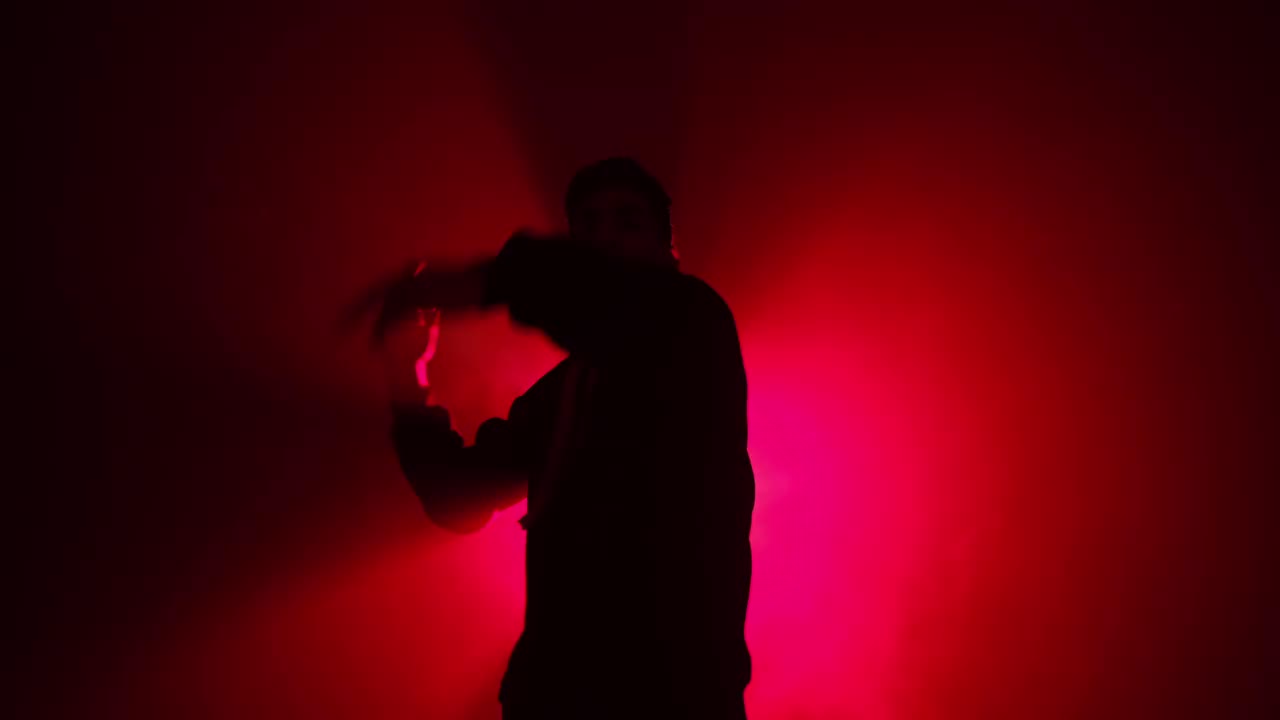 男人在红灯下跳霹雳舞的剪影视频素材