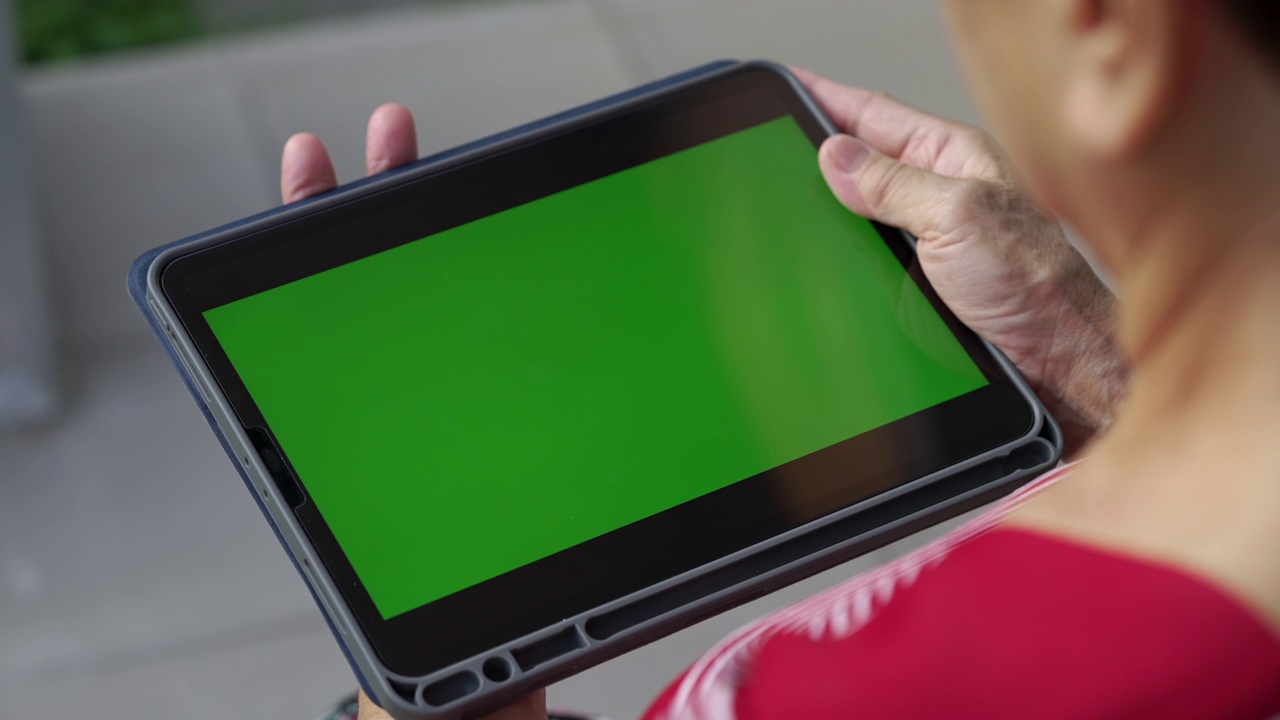 女士看着带有绿色屏幕的数码平板电脑。视频素材