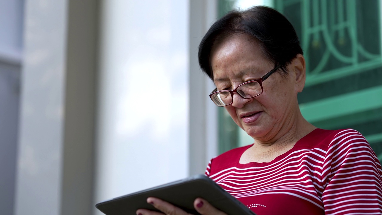 快乐退休女士，60岁，用触控板设备上网。视频素材
