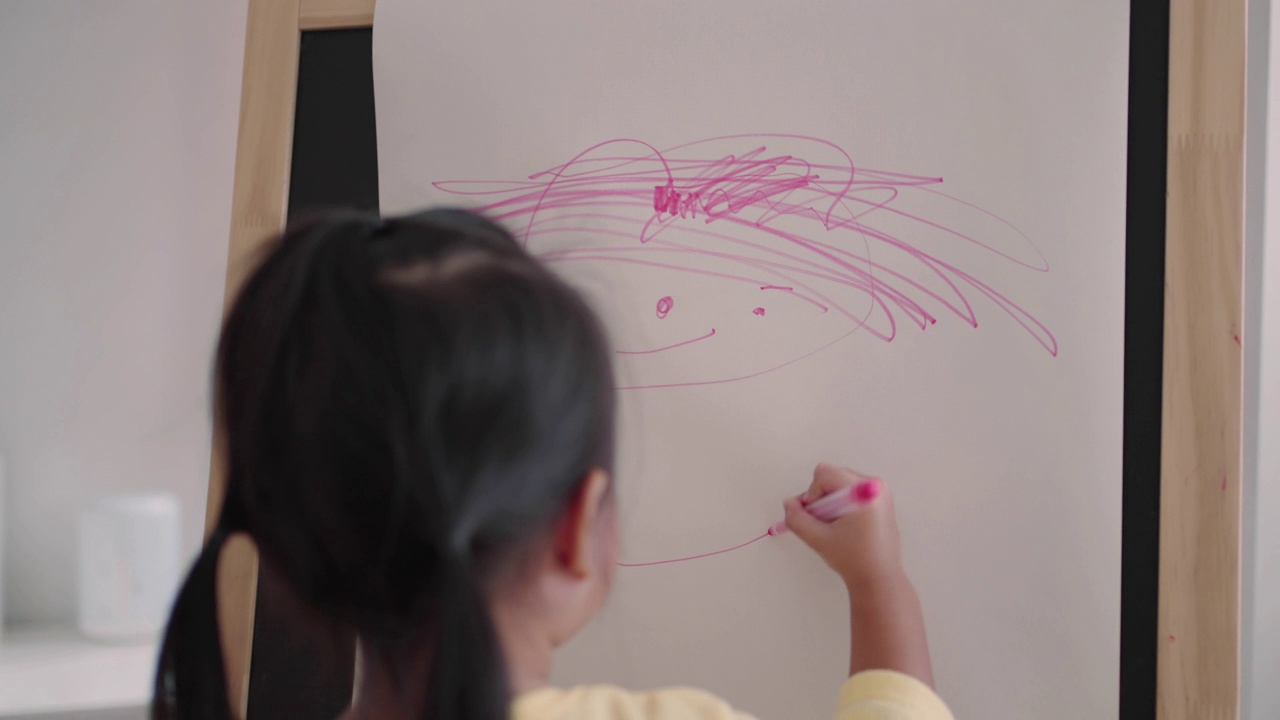 亚洲小女孩在纸上用彩笔画画视频素材