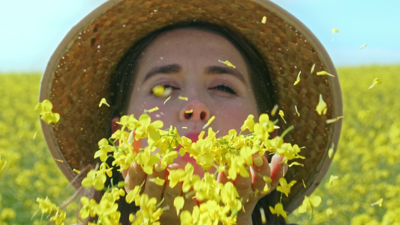 一名年轻女子在乡村吹花瓣的4k视频片段视频下载