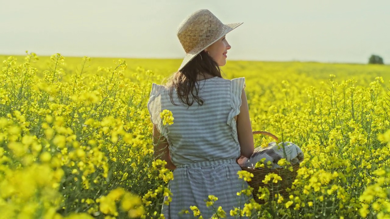 一名年轻女子在农村的田野里摘花的4k视频片段视频素材