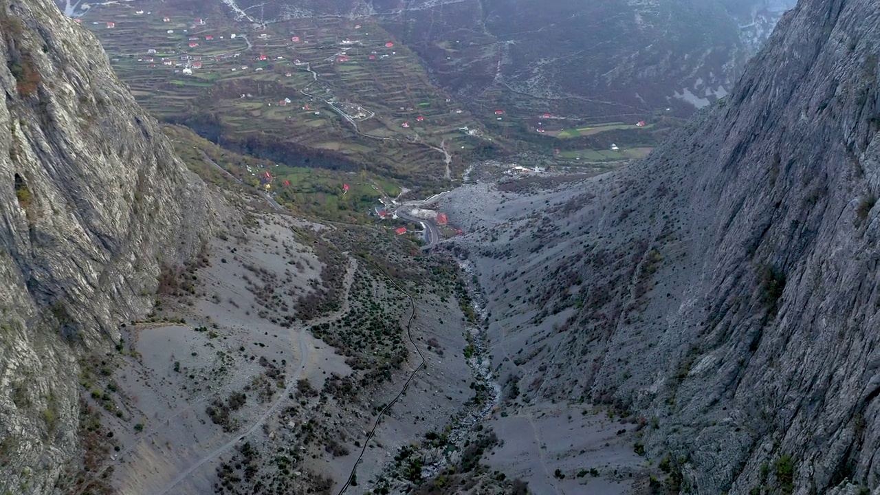 无人机拍摄的视频显示，在阿尔巴尼亚阿尔卑斯山脉Selcë村的两座山之间，飞机正朝着梯田农场飞行视频下载