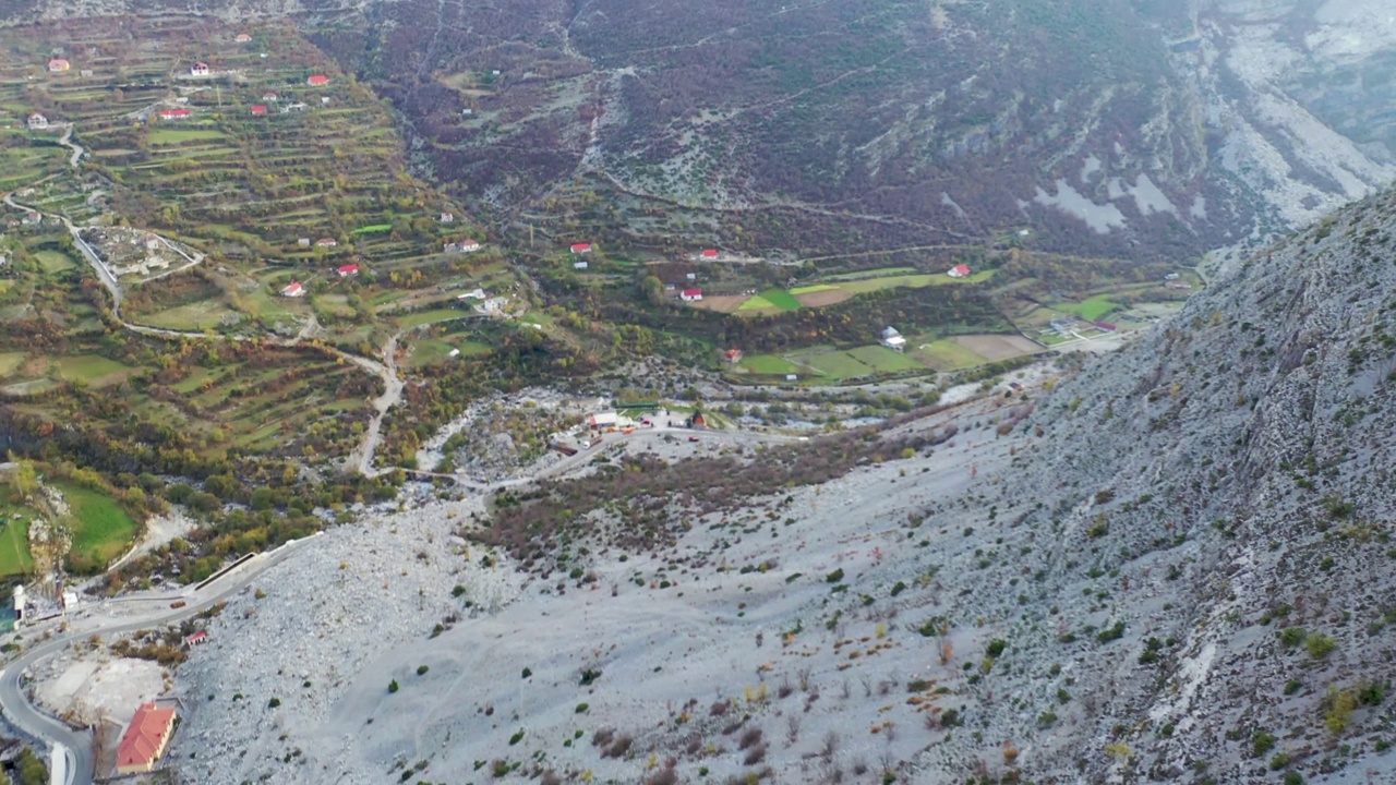 无人机拍摄的视频显示，在阿尔巴尼亚阿尔卑斯山脉Selcë村的两座山之间，飞机正朝着梯田农场飞行视频下载