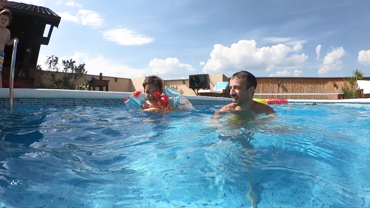 父子俩在游泳池里玩得很开心视频素材