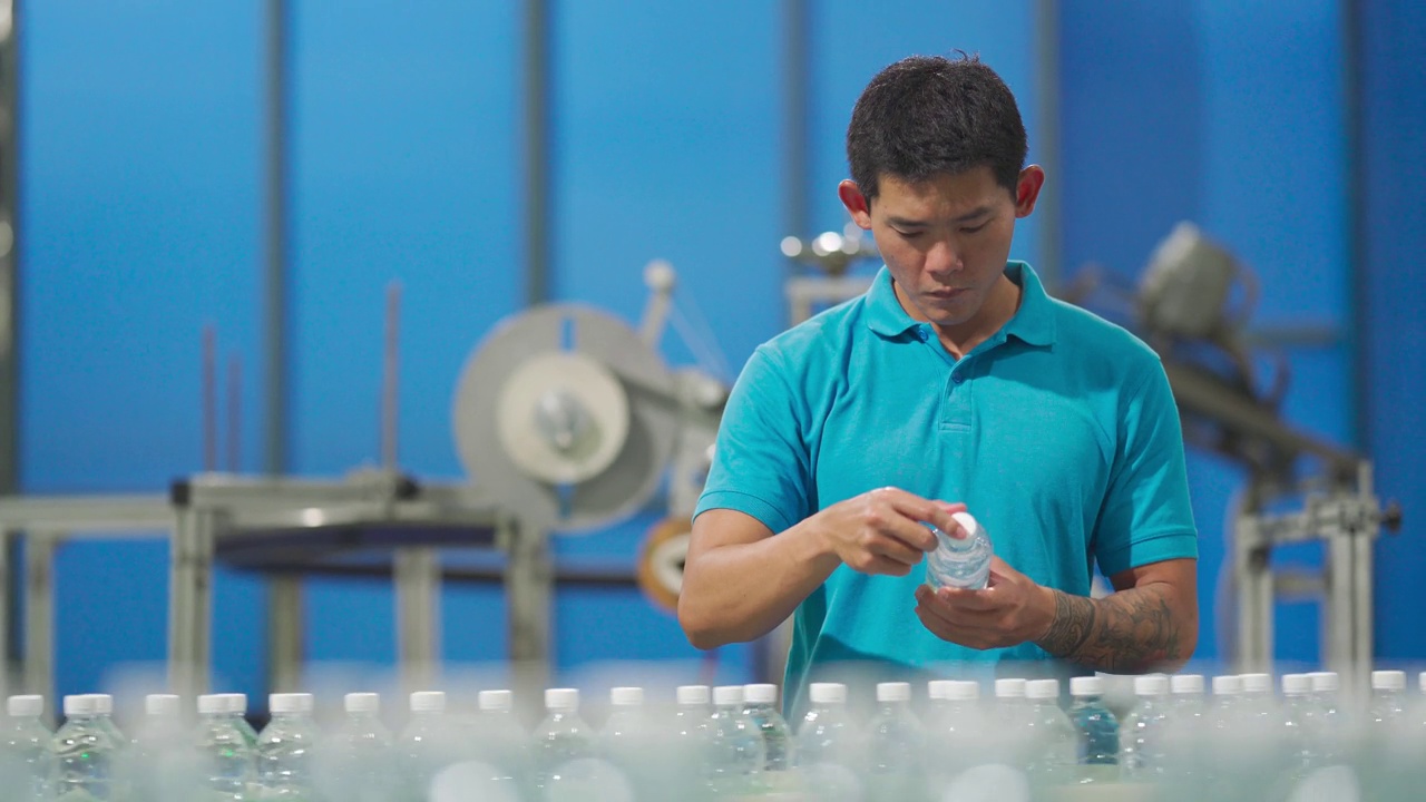 亚洲华人男性生产线工人检查水瓶瓶装矿泉水饮用水厂视频下载