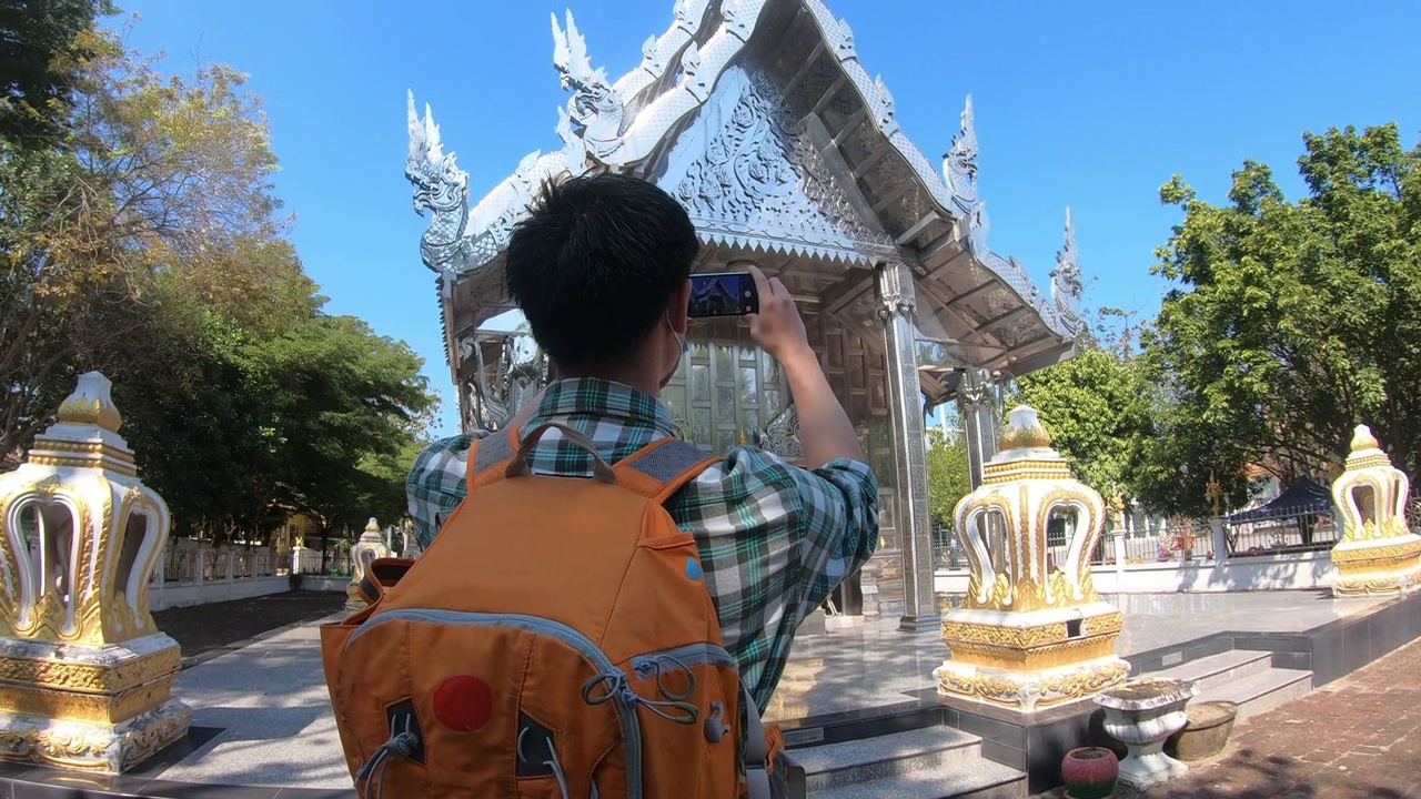 亚洲男子背包旅行者在度假期间用走在古塔寺泰国建筑视频下载