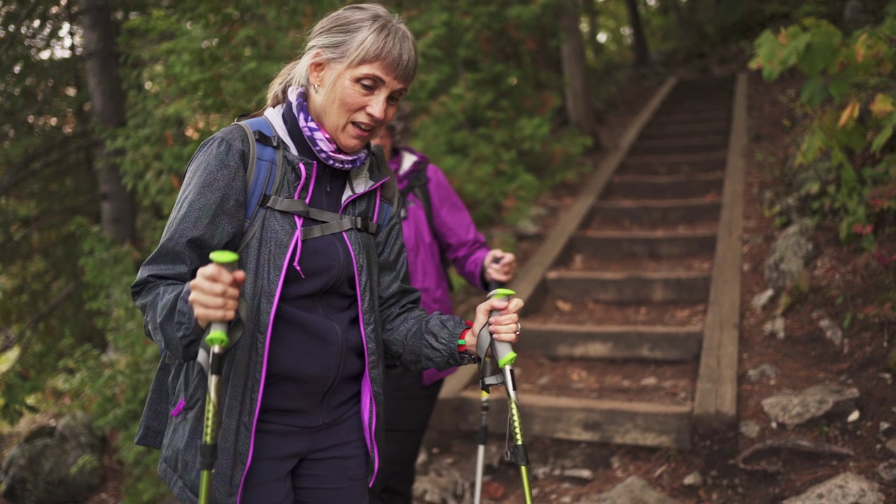 在森林里徒步走下楼梯时，年长的女性在聊天视频下载