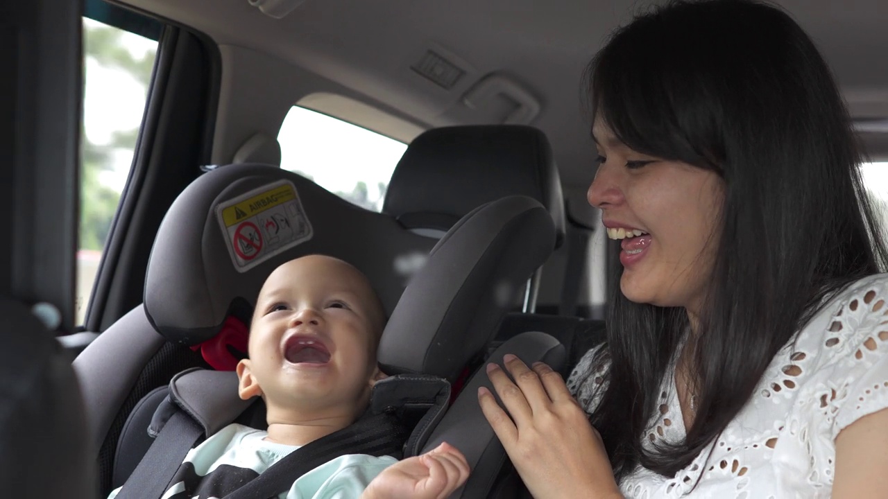 微笑的母亲和蹒跚学步的儿子玩在旅游海湾车视频下载