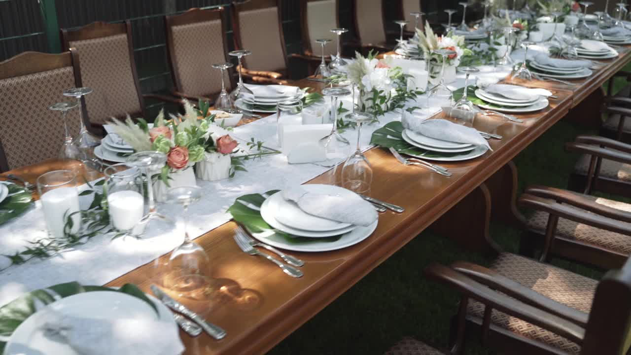 餐桌装饰为白色和绿色，点缀着鲜花和青草视频素材
