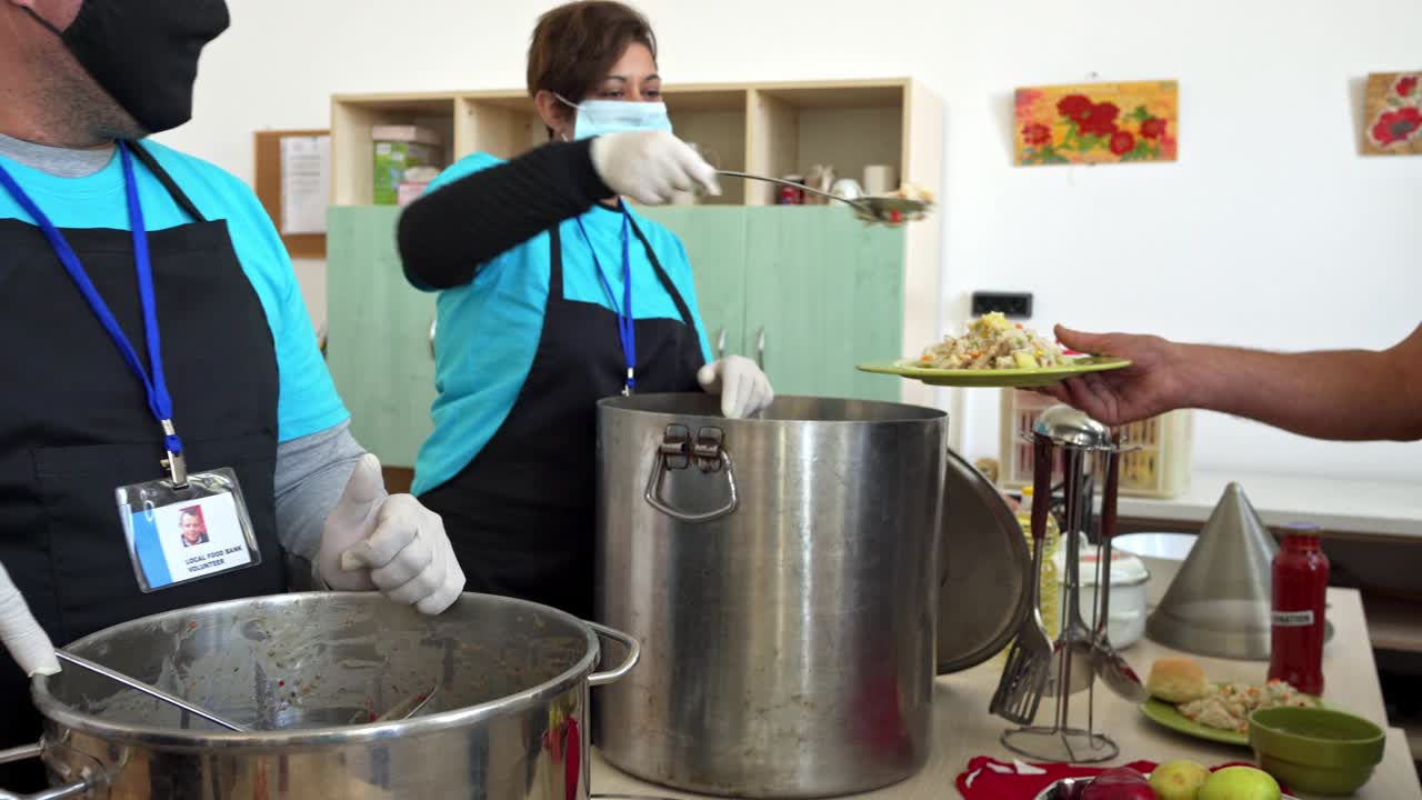 慈善工作者在救济厨房帮助饥饿的人视频下载
