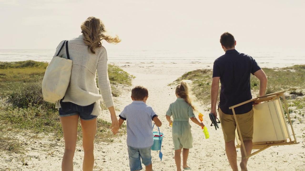 一对夫妇和他们的两个孩子在海滩上的4k视频视频素材
