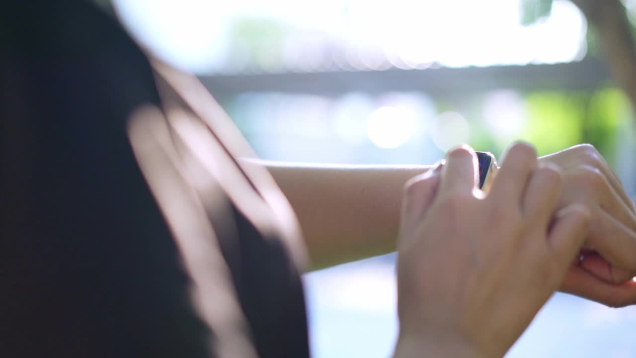 女性使用智能手表和智能手机视频下载