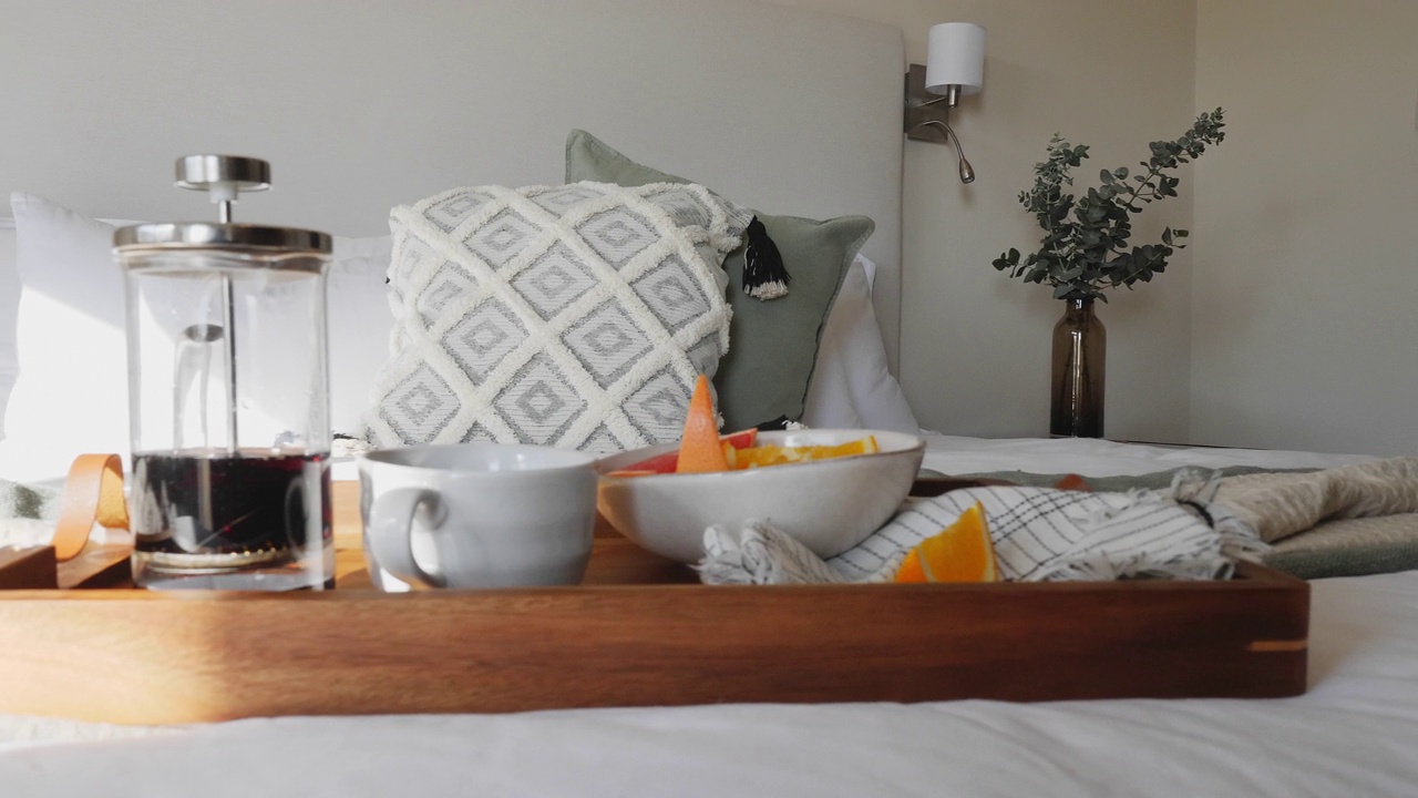 法式压滤咖啡和水果早餐托盘上阳光明媚的床视频下载