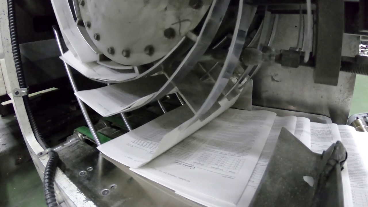 在印刷机的传送带上机械折叠的报纸视频素材