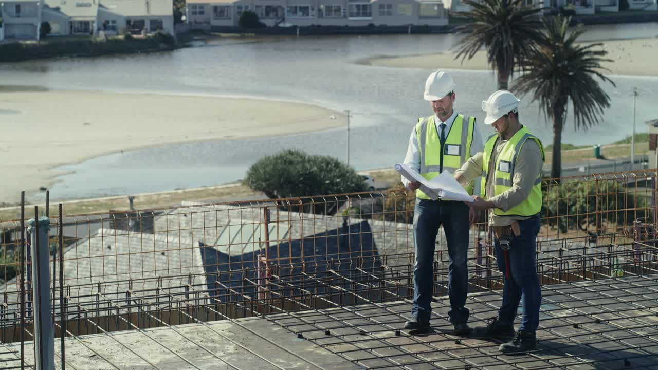 两名男子在建筑工地一起工作时看建筑图纸的4k视频视频素材
