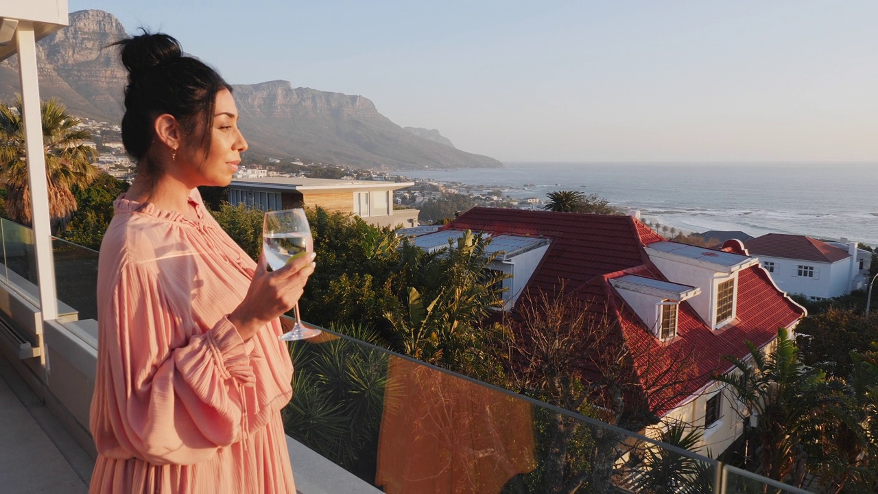 女人喝白葡萄酒在豪华露台与风景海景视频下载