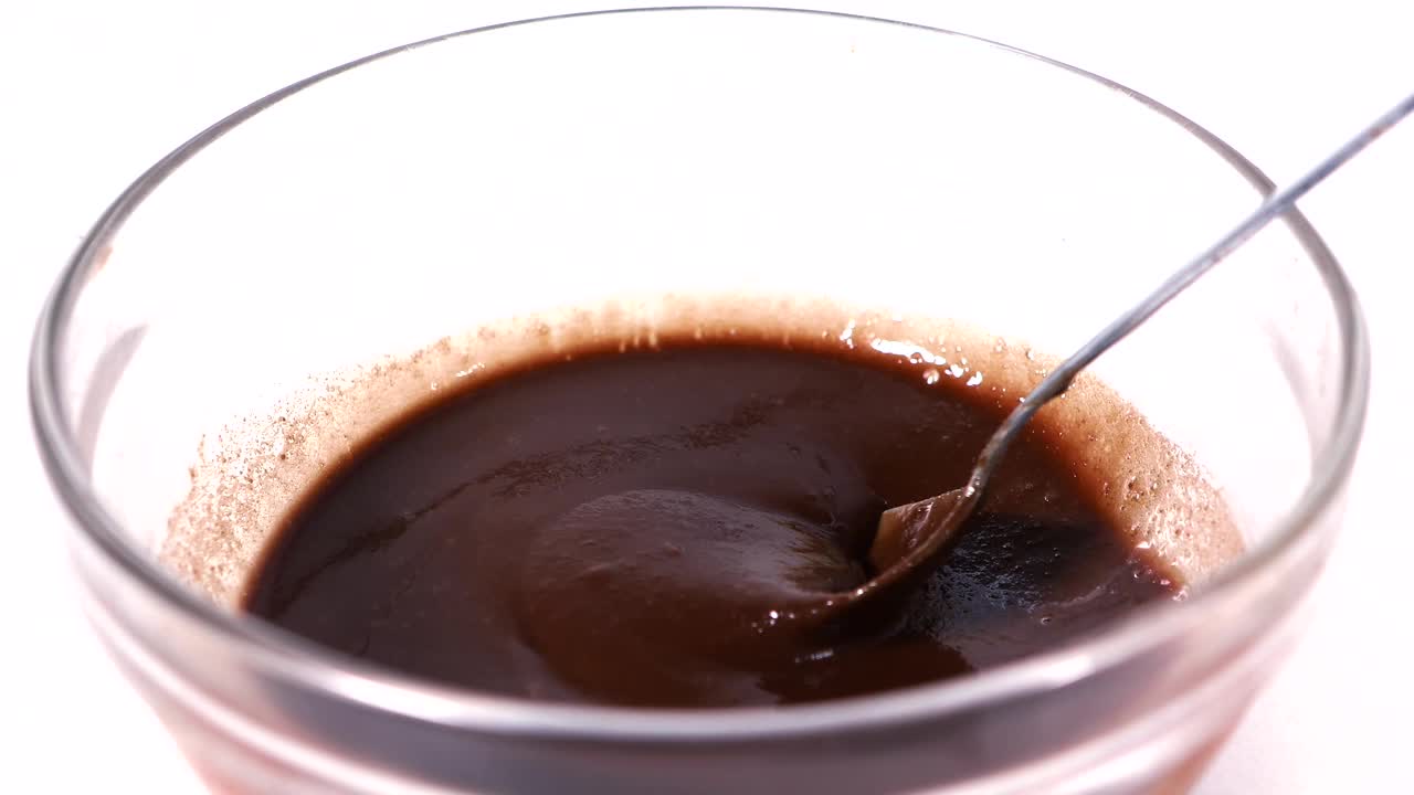 用勺子在碗里搅拌液态巧克力的视频片段。4K分辨率专业拍摄视频下载