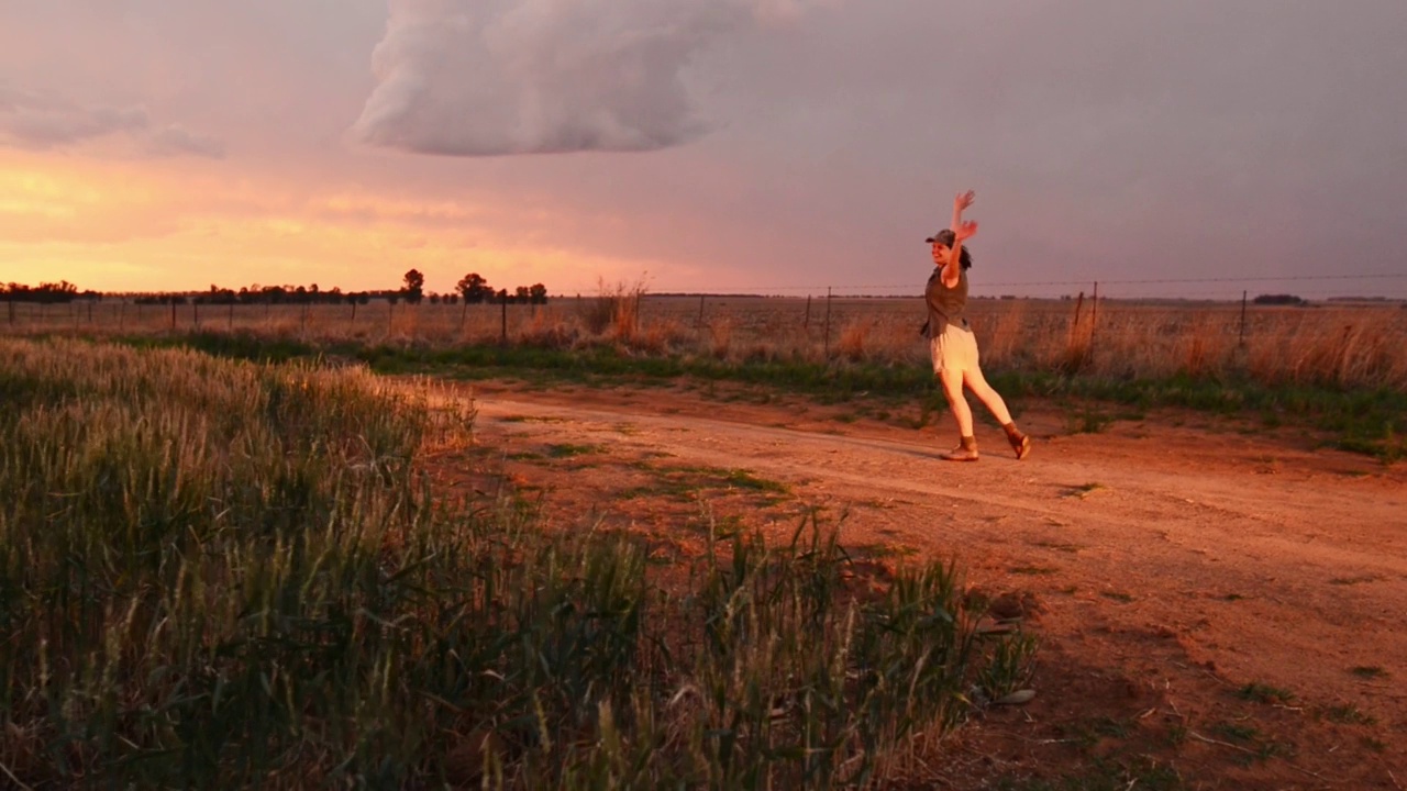 无忧无虑的年轻女子在黄昏的麦田里跳舞视频素材