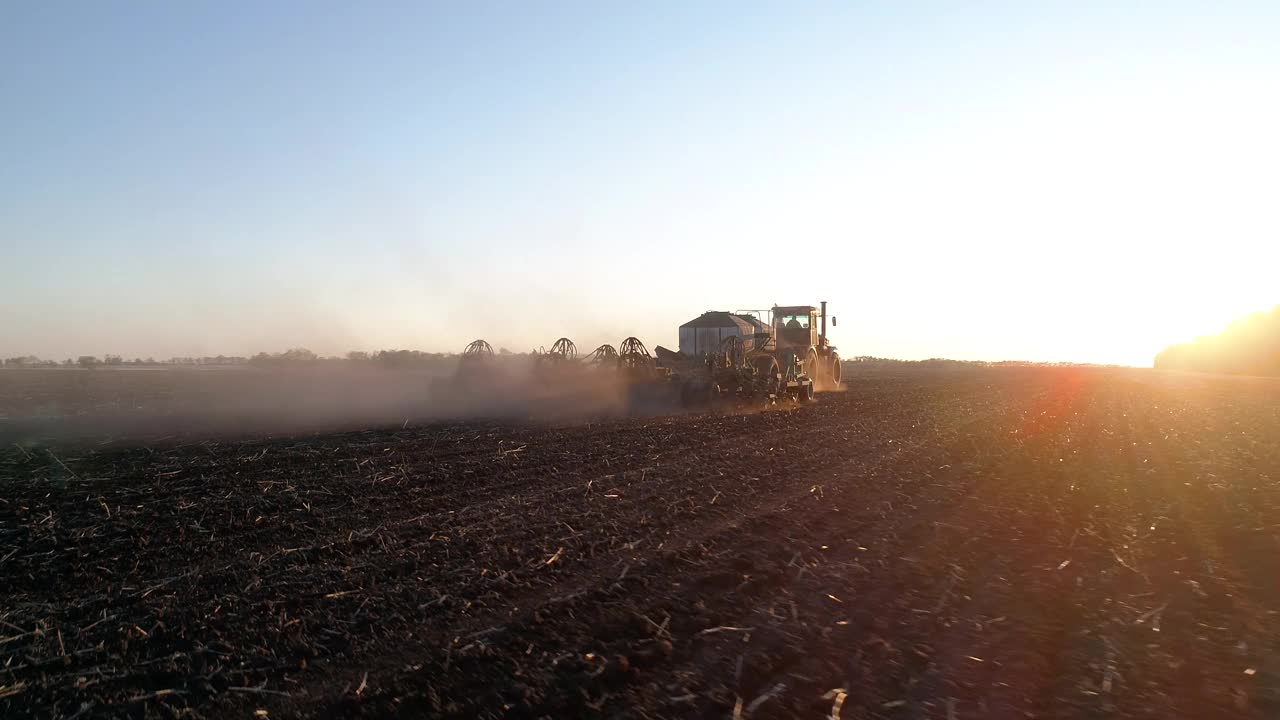 农业工作通过农村机械或拖拉机在夕阳田，自然农场视频素材